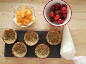 轻轻松松就脱模出来了，如果费力的话，可以用小刮刀沿着模具划一圈脱模。就是一个完整的燕麦杯啦！接着处理下水果，樱桃清洗干净，樱桃梗不要拿掉哈。芒果去皮切小块。酸奶装入裱花袋备用。