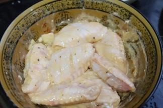 4.加入一勺植物油，用手将各种调味料和鸡翅抓匀腌制一个小时。鸡翅表面能裹上一层薄薄的面粉糊最佳，现成的cook100法式黑椒烤肉料里盐和其它配料的用量都搭配好了，比自己乱搭的味道要好，特别像饭店里的鸡翅味道，不要在另外添加盐和其它调味料了。