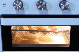 6.烤箱提前预热，下层放一个不粘的烤盘接鸡翅中滴下来的油，预热好以后把鸡翅送入烤箱中层，选择空气炸模式，大约200度20分钟。