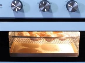 6.烤箱提前预热，下层放一个不粘的烤盘接鸡翅中滴下来的油，预热好以后把鸡翅送入烤箱中层，选择空气炸模式，大约200度20分钟。