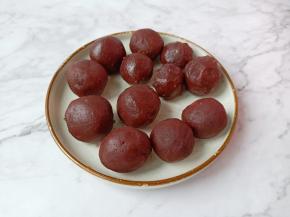 豆沙按扁一点包上蛋黄揉圆。