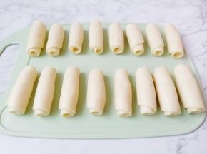 18克的油皮包上12克的油酥包起来，擀成长条状从上到下卷起来，盖上保鲜膜醒15分钟。