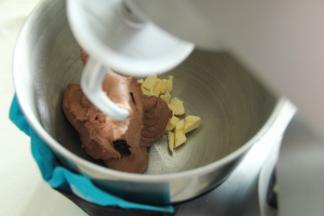 厨师机开一档，将材料混合成团。然后转2-3档打到略光滑，能扯出粗膜的状态。然后加入盐和软化好的黄油。（夏天，我的打面桶上绑了冰袋控制面温）