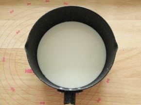 牛奶倒入不粘奶锅，细砂糖倒入牛奶中。开小火加热煮沸。要不停搅拌。