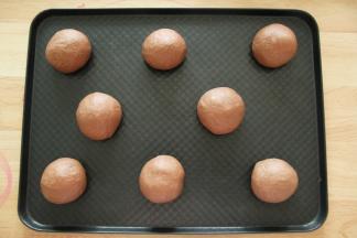 右手反C状握住面团，逆时针滚圆面团，排入烤盘。