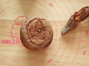 冷凉后，将冰心馅料取出，装入裱花袋（最后用泡芙打馅的花嘴，实在没有，小号圆嘴也可），餐包底部戳洞，裱花嘴45度角插入，360度转圈挤入馅料即可。