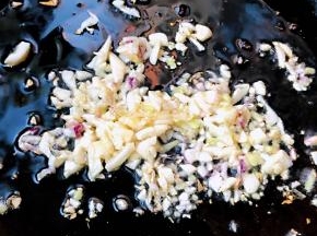 锅中倒入底油加热放入姜和蒜粒爆香