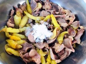 晾凉的鸡胗放入泡椒汤中同时放入糖、盐、味精拌匀盖上保鲜膜放入冰箱冷藏六个小时