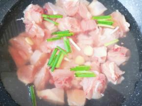 鸡块凉水入锅，加入料酒、小葱段和生姜片烧开焯水。