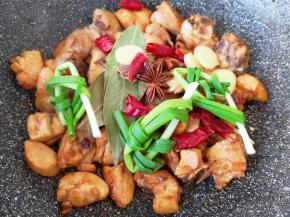 下入小葱结、生姜片、干红辣椒、八角、桂皮和香叶炒香。