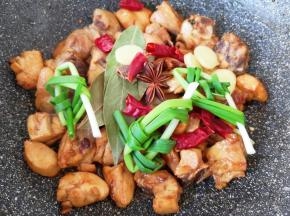 下入小葱结、生姜片、干红辣椒、八角、桂皮和香叶炒香。