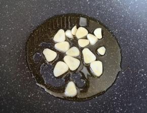 炒锅内倒适量的食用油烧热，下入蒜片煸香。