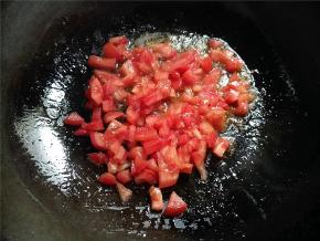 再倒2汤匙油，倒入番茄丁煸炒至油变红色。