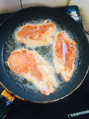 锅烧热倒入适量的油，放入腌制好的鸡胸肉中小火慢煎！