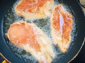 锅烧热倒入适量的油，放入腌制好的鸡胸肉中小火慢煎！