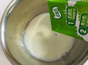 将一盒250ml的常温牛奶倒入容器中！