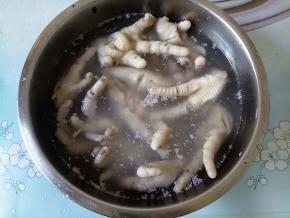 煮好的鸡爪捞出，迅速过凉白开，一是降温让鸡爪Q弹，二是洗去脚爪上的白沫。