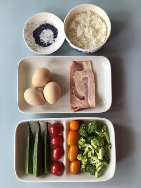 准备好食材，秋葵洗净去蒂，西兰花洗净切成小朵，圣女果洗净。米饭可以前一天晚上睡前在电饭煲里放好米和水，预定好时间，早上起床就自动煮好了。