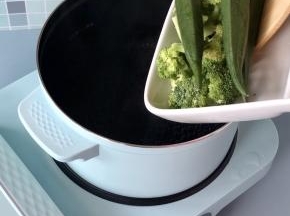 东菱早餐机的煮锅倒入适量水，烧开后下入秋葵和西兰花，焯烫3分钟左右。