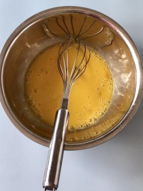 三明治机在煎培根的同时，可以用平底锅来煎鸡蛋卷，盆中打入三个鸡蛋，加入少许盐，搅拌均匀，如果要蛋液更细腻一些，可以过一下筛。