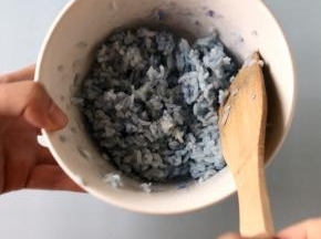用木铲把米饭拌匀，就成了蓝色的米饭。