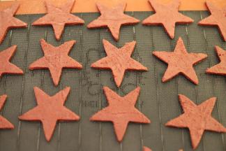 取出面团，再次擀平面团，大概厚度为3-5毫米，用五角星饼干切成切好五角星形状，放在透气垫上。