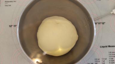 将面团搓圆放入盆内，盖上保鲜膜一发。