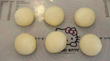 将面团轻压排气后平均分成6份，盖上保鲜膜松弛15分钟。