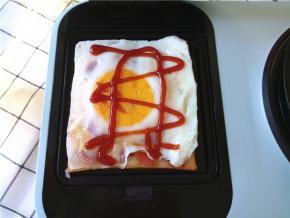 放上煎好的鸡蛋，多余的边角切下来，当然不能忘了番茄酱。