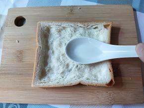 吐司用一个汤匙将中间部分压扁。