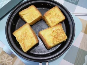 蛋液凝固后，小心将吐司块翻面，两面煎得微焦。
