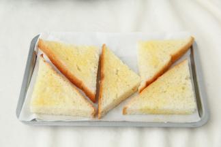 然后用毛刷将吐司块正反面，四周都刷上一层蜂蜜黄油混合液体。尽量刷均匀一些。