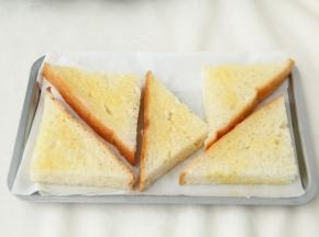 然后用毛刷将吐司块正反面，四周都刷上一层蜂蜜黄油混合液体。尽量刷均匀一些。