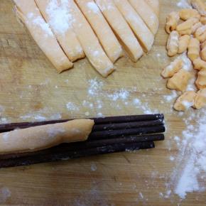 拿4根筷子，把切好的面条放在筷子上，用刀切成一小块，向外按压面团，就成了海螺的形状