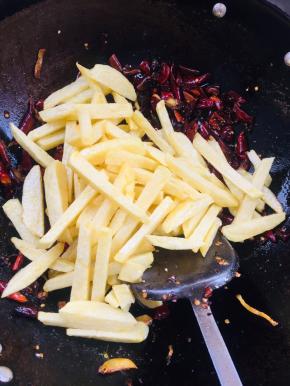 放入炸好的土豆条翻炒均匀！