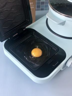然后磕入一个鸡蛋，盖好上盘，煎制3分钟。