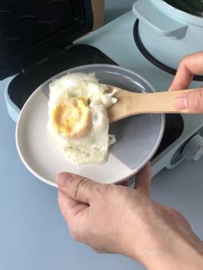 三明治机提示音响后，鸡蛋煎好了，盛出备用。