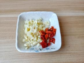 蒜剥皮拍一下再切成碎末，辣椒切小段备用。