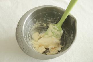 用刮刀将黄油和糖粉按压混合，防止一会打发的时候糖粉飞溅。