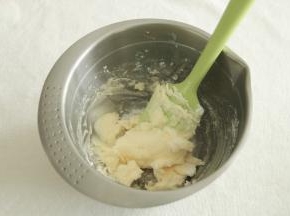 用刮刀将黄油和糖粉按压混合，防止一会打发的时候糖粉飞溅。