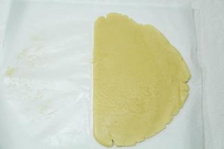 将冷藏好的面团取出，放在油纸上，盖上一张油纸，用擀面杖擀开，大约0.5-0.6厘米厚。