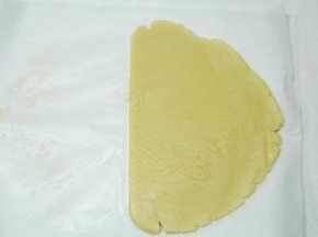 将冷藏好的面团取出，放在油纸上，盖上一张油纸，用擀面杖擀开，大约0.5-0.6厘米厚。