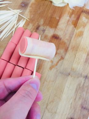 取一个火腿段，卷上土豆片，用牙签固定住！