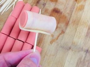 取一个火腿段，卷上土豆片，用牙签固定住！