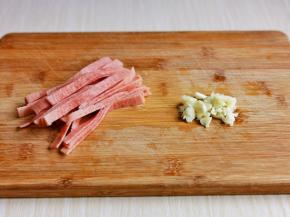培根切条，大蒜去皮切碎。