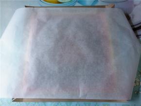 蛋糕出炉后轻震几下，盖上油纸，将蛋糕倒扣出来，再翻回来，晾两三分钟，再盖上油纸晾凉。油纸要比蛋糕长一半，后面才好卷。