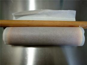 借助擀面杖将蛋糕从草莓这头卷起，稍微收紧一下，具体手法请网上搜索大神们的视频吧。可以用胶带将油粘固定一下，然后冰箱冷藏一小时以上。剩下的奶油也放冰箱冷藏。