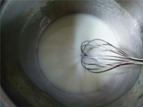 取一个干净的盆，加入玉米油和牛奶，用蛋抽搅打，乳化均匀。