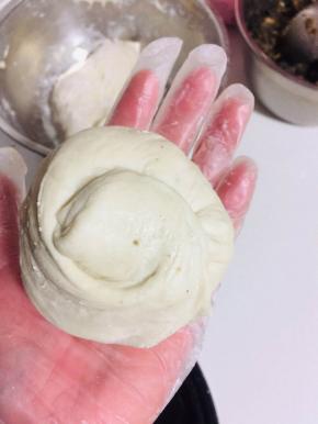 放入适量的酸菜猪油渣馅儿，像包包子一样包起来，收口，按扁！