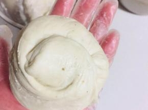 放入适量的酸菜猪油渣馅儿，像包包子一样包起来，收口，按扁！